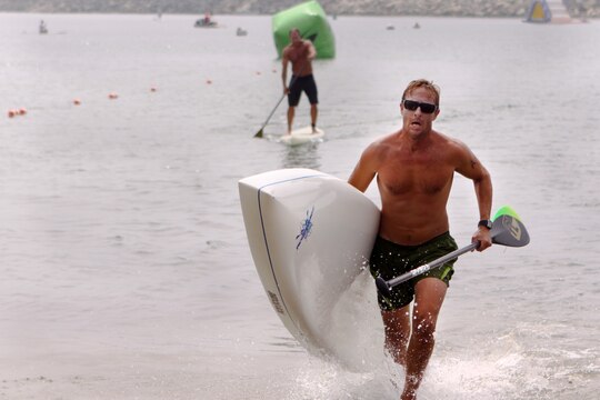 Mark Quest, 41, charges the beach as he completes one of three miles of the Age Group Amphibious Assault Stand-up Paddleboard race during the Water Warrior Beach Festival at Del Mar beach here, Sept. 14.