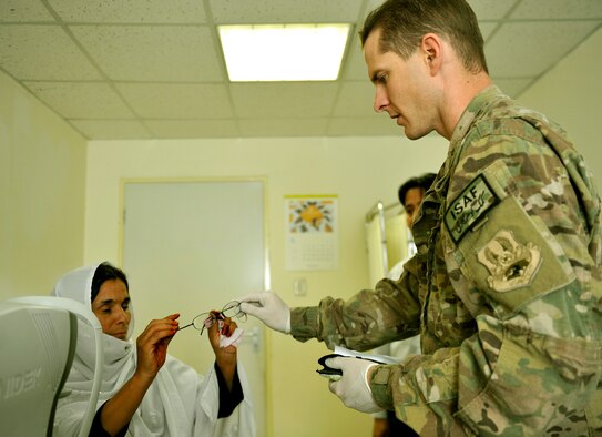 Maj. Marcus Neuffer, 455th Expeditionary Medical Group ophthalmologist, hands an Afghan patient glasses matching her prescription in the Korean Hospital on Bagram Air Field, Afghanistan, Sept. 18. Five months ago after arriving on Bagram, he established a program to provide glasses to Afghan and coalition members in need. The glasses come from former patients and non-profits. This is the second time they have held an eye glasses clinic here. He is deployed from Keesler Air Force Base, Miss. (U.S. Air Force photo/ Staff Sgt. Stephenie Wade)
