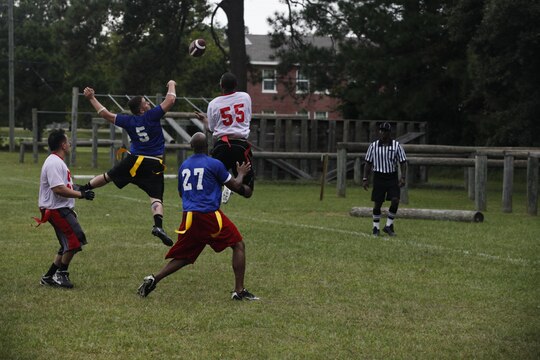 A wide receiver from Special Operations Training Group tries to catch a pass as two defenders from 2nd Marine Special Operations Battalion try to block the pass during the flag football tournament aboard Stone Bay Rifle Range, Sept. 21.