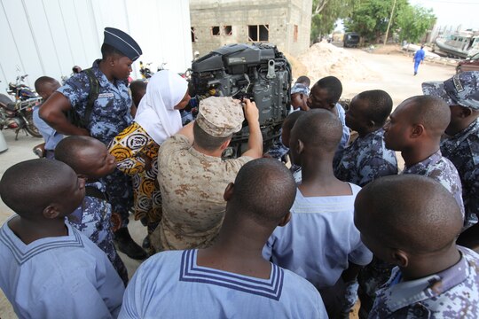A group of sailors with the Togolese Navy watch as Lance Cpl. Tyler Jackson, a Marine with Special-Purpose Marine Air-Ground Task Force Africa 14.1, works on a small-boat engine in Lomé, Togo, March 25. Jackson and Spence put together a week-long training program of classroom instruction and practical application so the two groups of service members could partner together to fix engines. Established in 2011, Special-Purpose Marine Air-Ground Task Force Africa 14.1 is charged with supporting U.S. Africa Command and Marine Corps Forces Europe and Africa’s theater security cooperation requirements.