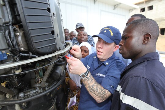 Petty Officer 3rd Class Brian Spence, a Coastguardsman with U.S. Coastguard Station Seattle, explains the electronic control module of a small-boat engine a group of sailors from the Togolese Navy in Lomé, Togo, March 25. Spence flew from Seattle to attend a week-long training program designed to demonstrate proper small-boat engine mechanics to a group of sailors from the Togolese Navy.