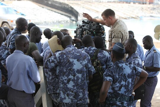 A group of sailors with the Togolese Navy watch as Lance Cpl. Tyler Jackson, a Marine with Special-Purpose Marine Air-Ground Task Force Africa 14.1, discusses small-boat engine mechanics in Lomé, Togo, March 25. Jackson put together a week-long training program of classroom instruction and practical application so the two groups of service members could partner together to fix engines. Established in 2011, Special-Purpose Marine Air-Ground Task Force Africa 14.1 is charged with supporting U.S. Africa Command and Marine Corps Forces Europe and Africa’s theater security cooperation requirements.