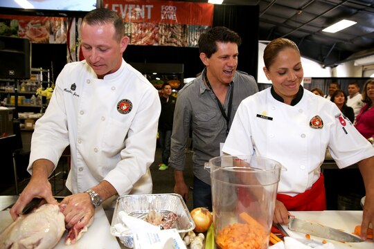 Gunnery Sgt. Matthew Jacobs and Staff Sgt. Karla Arce prepare their meal while judge Troy Johnson taunts them at the Boiling Points competition held at the Del Mar Fairgrounds April 16. Boiling Points is a competition hosted by Aaron Williams, the corporate division chef for Food Fanatics, Los Angeles. The competition challenged the Marine Corps, Army, Navy and Coast Guard to go head-to-head in a 45-minute cooking competition. The Marine team took 1st place with their dish of an appetizer of fried eggplant and seared scallop caprese, and an entrée of seared duck, sweet potatoes and a fruit medley with a star fruit and horn melon sauce. Jacobs is the enlisted aid for the I Marine Expeditionary Force’s commanding general, Arce is the enlisted aide for MCI West and Marine Corps Base Camp Pendleton’s commanding general and Johnson is a Food Network judge.