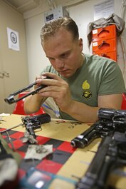 Corporal Michael Yodice inspects and cleans M9 service pistols aboard amphibious transport dock ship USS Anchorage (LPD 23). Yodice is from Butler, N.J., and the sole Marine Corps armorer aboard the ship. As a small arms repair technician with 1st Maintenance Battalion, 1st Marine Logistics Group, he was responsible for making sure the different weapons systems worked for the nearly 200 Marines and sailors with his current