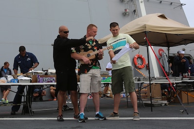 Sgt. Aren King, left, a light armored vehicle mechanic with 1st Light Armored Reconnaissance Battalion, 1st Marine Division is cheered on by his fellow Marines alongside Lance Cpl. Michael Sigur, a supply clerk with 1st Maintenance Battalion, 1st Marine Logistics Group. King and Sigur won second and third place respectively during a talent show as part of Steel Beach, a barbecue held aboard amphibious transport dock ship USS Anchorage (LPD 23) to build unit cohesion, April 13, 2014, as part of Special Purpose Marine Air Ground Task Force Association of Southeast Asian Nations. SPMAGTF-ASEAN, aboard Anchorage, recently completed a mission to support U.S. Secretary of Defense Chuck Hagel during a press conference with delegates and media personnel from the ASEAN in Hawaii, April 1-4, 2014 and is currently at sea conducting further training and maintenance on equipment. King is from Orlando, Fla.