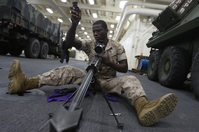 Lance Cpl. Vladimir Charles, a scout with 1st Light Armored Reconnaissance Battalion, 1st Marine Division, performs maintenance on the .50 caliber sniper rifle while part of Special Purpose Marine Air Ground Task Force ASEAN, aboard amphibious transport dock ship USS Anchorage (LPD-23), April 15, 2014. As part of SPMAGTF-ASEAN, 1st LAR showcased their territorial defense capabilities alongside units with 1st MLG on their mission to support the U.S. Secretary of Defense Chuck Hagel, during the Association of Southeast Asian Nations press conference in Hawaii, April 1-4, 2014. SPFMAGTF-ASEAN conducted further training at sea starting April 7, 2014. Charles is from Brooklyn, N.Y. (U.S. Marine Corps photo courtesy of Lance Cpl. Shaltiel Dominguez/ Released)