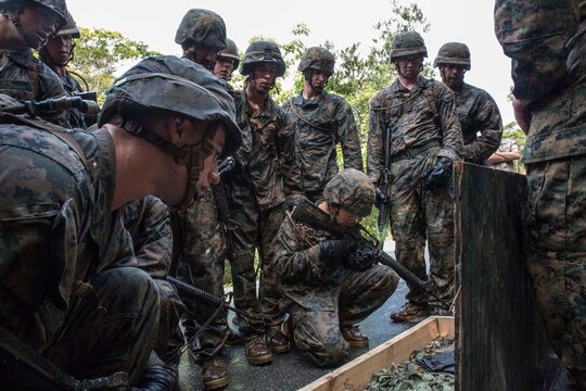 Marines memorize items contained in a box as part of a “Kim’s game” during an endurance course April 17 at the Jungle Warfare Training Center on Camp Gonsalves. The Marines look at the items early in the course and then have to tell the instructors what items were in the box just before the last leg of the event. The simple game tests the participant’s mental capacity while enduring stressful and fatiguing activity. The Marines are with various units assigned to Combat Assault Battalion, 3rd Marine Division, III Marine Expeditionary Force. (U.S. Marine Corps photo by Cpl. Stephen D. Himes/Released)