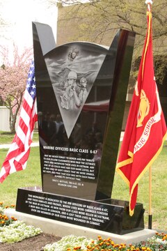The 6-67 Memorial sits between the U.S. flag and the Marine Corps flag during the memorial’s dedication at The Basic School on April 25, 2014. The memorial was dedicated to the class who suffered 50 casualties and more than 200 wounded Marines.