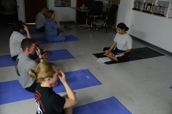 U.S. Air Force Senior Airman Kandie Ibarra (right), a lab technician assigned to the 455th Expeditionary Medical Group starts her co-workers in a variation of the sukhasana or easy pose during a yoga class June 24, 2014 at the Craig Joint Theater Hospital, Bagram Airfield, Afghanistan. Ibarra leads the class two nights a week to give medical personnel a quiet getaway from the stresses of the trauma ward of the hospital. CJTH is one of the busiest hospitals in Afghanistan. Ibarra is a native of Blackfoot, Idaho and deployed from Keesler Air Force Base, Miss. (U.S. Air Force photo by Master Sgt. Cohen A. Young/Released)
