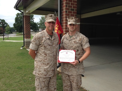 CWO4 Matthew Studer, Executive Officer of Alpha Company, Marine Corps Detachment Fort Lee, and Sgt Justin Brown, Aerial Delivery Instructor, with Sgt Brown’s Certificate of Commendation for being selected as the Instructor of the Quarter for Alpha Company.  (Photo provided by CWO4 Allen Ostermann, Marine Corps Detachment Public Affairs Officer/Released)