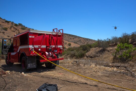 A CH-53E Super Stallion with the 3rd Marine Aircraft Wing carries an empty bucket to a simulated fire during the wildland firefighting exercise with the Miramar Fire Department aboard Marine Corps Air Station Miramar, Calif., Aug. 14. The fire department here can call upon 3rd MAW Marines and reliably assist from the ground and the air when other fire combating elements like the United States Forest Service request additional assets to support fires throughout California.