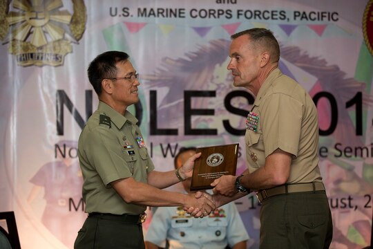 Coglianese, commanding general, 1st Marine Logistics Group, presents Philippine Brig. Gen. Arthur Ang, with a gift of appreciation at the closing ceremony of Non-lethal Weapons Executive Seminar (NOLES) 2014, August 16. NOLES is an annual field-training exercise and leadership seminar sponsored by U.S. Marine Corps Forces Pacific, and hosted by various nations throughout the Asia-Pacific. This is the 13th iteration of NOLES with members from the AFP, and Philippine National Police participating. (U.S. Marine Corps photo by Cpl. Erik Estrada)