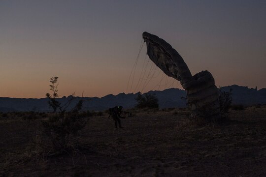 A U.S. Marine Critical Skills Operator with 1st Marine Special Operations Battalion, Marine Corps Forces, Special Operations Command, lands in the Arizona desert, with a ram-air canopy parachute system, during a double-bag static line (DBSL) parachute training course, Aug 29, 2014.  The DBSL course was an introduction to the High Altitude, High Opening (HAHO) insertion method utilized by Special Operations Forces. (U.S. Marine Corps Photo by Lance Cpl. Steven M. Fox/Released)