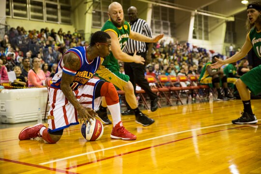 Harlem Globetrotters guard Saul ‘Flip’ White, left, displays his ball handling wizardry to the crowd Dec. 9 at The Foster Field House on Camp Foster. The Harlem Globetrotters displayed their basketball artistry to service members and their families in a showdown with their rivals, the Washington Generals. The event was a part of the Harlem Globetrotters 13th military tour, in which the team travels overseas to U.S. military installations to provide memories of home during the holidays. The game was presented by Navy Entertainment, Leatherneck Tour and Marine Corps Community Services. 