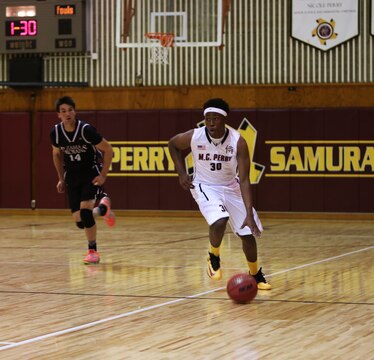 Jarell Davis, a senior with the Matthew C. Perry Samurai basketball team, dribbles the ball up the court during the first of two home games against the Zama American High School Trojans, Dec. 12, 2014, at the high school gymnasium aboard Marine Corps Air Station Iwakuni, Japan. The Samurai defeated the Trojans 45-28 in the first game and 59-54 in the second. 