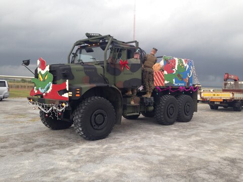 Marines prepare a 7-ton truck as a float during the 2014 Camp Kinser Tree Lighting Ceremony and Holiday parade November 28 here. Approximately 300 service members, families and Okinawa community members watched a parade of military vehicles dressed as Christmas floats. The event included several performances, such as taiko drummers and hula dancers. A Christmas tree was lit to mark the end of the event. 