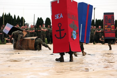 Marines with Combat Logistics Regiment 15, 1st Marine Logistics Group, compete in body jousting, an event in which Marines raced across a wet and soapy tarp with unit-decorated refrigerator boxes over their heads, during the regiment’s physical training contest aboard Camp Pendleton, Calif., Jan. 24, 2014. In addition to blindly running across a slick surface, Marines also competed in a pugil-stick match and participated in a boots and utilities formation run. The winner of the overall physical fitness competition was Maintenance Battalion.