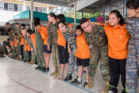 Royal Thai and U.S. service members and students from Nakhon Ratchasima Punyanukul School in Nakhon Ratchasima, Kingdom of Thailand, partner together for a race during a community relations event for exercise Cobra Gold 2014 Feb. 11. CG 14 is a joint, multinational exercise conducted annually in the Kingdom of Thailand aimed at enhancing and increasing multinational interoperability. The U.S. service members are with Marine Aircraft Group 12, 1st Marine Aircraft Wing, III Marine Expeditionary Force.