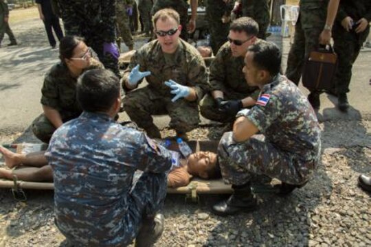 Petty Officer 3rd Class Joel Reidell, center, and Petty Officer Second Class Brenton Smith explain how to properly treat a mock patient that was exposed to a simulated chemical attack during the counter weapons of mass of destruction exercise aboard Wing One Royal Thai Air Force Base, Nakhon Ratchasima, Kingdom of Thailand, Feb. 16 during Exercise Cobra Gold 2014. CG 14 is a joint, multinational exercise conducted annually in the Kingdom of Thailand aimed at enhancing and increasing mission readiness and multinational interoperability. Smith is an aviation medical technician with Marine All Weather Fighter Attack Squadron 242, Marine Aircraft Group 12, 1st Marine Aircraft Wing, III Marine Expeditionary Force. Reidell is a field medical technician with Marine Wing Support Squadron 171, MAG-12, 1st MAW, III MEF.
