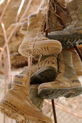 Over 200 pairs of boots hang from the ceiling of an old, damaged building at an undisclosed location in Southwest Asia.  The boots are part of a tradition that Airmen in the fuels career field started more than 20 years ago.  The fuels Airmen believe that if you discard an old pair of boots according to a specific ritual, you will not be tasked to return to the same location in the future.  (U.S. Air Force photo by Senior Master Sgt. Burke Baker)
