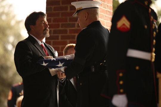 Assistant Commandant of the Marine Corps Gen. John Paxton Jr. presents the national flag to John James McGinty III’s son during the funeral of the former Medal of Honor recipient Jan. 23, 2014, at Beaufort National Cemetery in Beaufort, S.C. McGinty, a decorated Vietnam War hero and Marine Corps Recruit Depot Parris Island veteran, died Jan. 17, 2014, in his home in Beaufort at the age of 73.