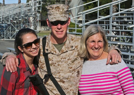Corporal Dylan Cook, a 21-year-old ammunition technician with Ammunition Company, 1st Supply Battalion, Combat Logistics Regiment 15, 1st Marine Logistics Group, poses for the camera with his wife, Julie, and mother, Dara, before leaving on a seven-month deployment to Afghanistan in support of Operation Enduring Freedom, Jan. 19, 2014. Cook is deploying with Combat Logistics Battalion 7, along with elements of 1st Explosive Ordnance Disposal Company, 1st Medical Battalion, 1st Dental Battalion and 7th Engineer Support Battalion, to support I Marine Expeditionary Force (Fwd) in assuming responsibilities as the logistics battalion for Regional Command (Southwest). 