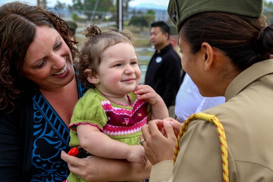 Heather Guerrero, left, raises her daughter, Olivia, toward Capt. Sara Minck, during a ribbon cutting ceremony for Pendleton's newest Community Counseling Center Jan. 24. The Marine Corps is working to provide an integrated behavioral health system so that service members and their families receive prevention and treatment services for their behavioral health needs on base, free of charge, when they need it most. Minck is the base's aide de camp.