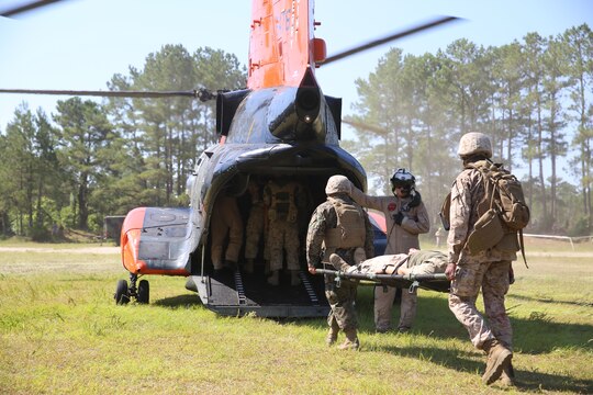 Marines and sailors with 2nd Medical Battalion, carry a patient toward a CH-46E Sea Knight during a mass casualty exercise aboard Marine Corps Air Station New River, June 19. The exercise trained service members on proper loading, offloading of patients on an aircraft, as well as proper care procedures after the patient has been delivered to the next medical care facility.