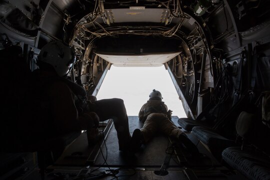 Crew chiefs with Marine Medium Tiltrotor Squadron (VMM) 166 keep watch outside of an MV-22B Osprey during a training flight from Marine Corps Air Station Miramar, Calif., July 24. The flight included confined-area landing and tactical-formations. 
