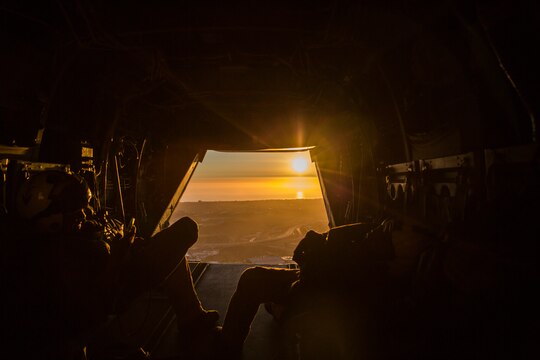 Crew chiefs with Marine Medium Tiltrotor Squadron (VMM) 166 watch the sunset outside of an MV-22B Osprey near the end of a training exercise flying back to Marine Corps Air Station Miramar, Calif., July 24. The flight included confined area landing and tactical formations.