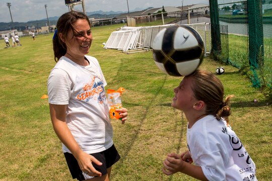 Samantha Porter, a coach with the Southern California Seahorse Soccer Club, teaches a soccer camp participant how to head juggle at Penny Lake fields aboard Marine Corps Air Station Iwakuni, Japan, July 23, 2014. The soccer camp was hosted by the Seahorses in association with Marine Corps Community Services to provide Iwakuni youth the opportunity to improve their soccer skills.