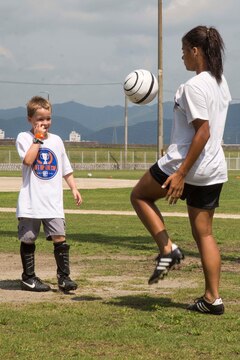 Kalaila Holt, a member of the Southern California Seahorse Soccer Club, practices juggling techniques with a Seahorse soccer camp participant at Penny Lake fields aboard Marine Corps Air Station Iwakuni, Japan, July 23, 2014. The Seahorses are a motivational, religious soccer team who carry out numerous after-school clinics, camps, international tours and many other outreach programs throughout Asia and the U.S. west coast.  
