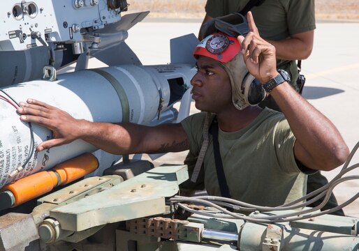 Lance Cpl. James McNeil, an aviation ordnance Marine with Marine All-Weather Fighter Attack Squadron (VMFA(AW)) 225 “Vikings,” directs ordnance Marines as they load a MK-82 low-drag bomb on an F/A-18 Hornet during high-explosive ordnance loading training at the combat aircraft loading area aboard Marine Corps Air Station Miramar, Calif., July 29. These Marines are also responsible for conducting system checks on all the aircraft before loading any ordnance.