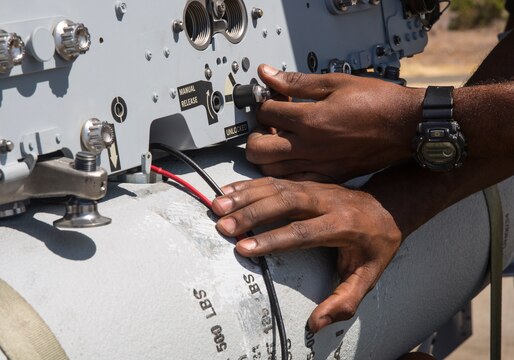 An aviation ordnance Marine with Marine All-Weather Fighter Attack Squadron (VMFA(AW)) 225 “Vikings” locks in place a MK-82 low-drag bomb on an F/A-18 Hornet during high-explosive ordnance loading training at the combat aircraft loading area aboard Marine Corps Air Station Miramar, Calif., July 29. The ordnance Marines also loaded the aircraft with LAU-10 rockets during the training.  