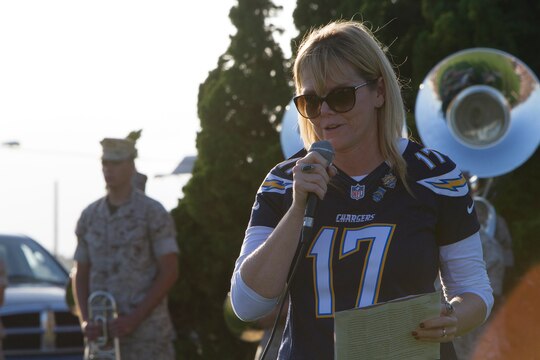 Retired Navy Senior Chief Petty Officer Melissa Haskins speaks during an evening colors ceremony aboard Marine Corps Air Station Miramar, Calif., June 10. Marines and Sailors of the 3rd Marine Aircraft Wing and MCAS Miramar hosted the event to recognize the services rendered by the San Diego Chargers to honor the military community. Haskins was personally effected by the Chargers when she underwent chemotherapy for leukemia. The team invited her to watch a practice and to eat lunch with them. Haskins claims that moment positively impacted her treatment and was thankful to be able to give recognition and appreciation back to the team.