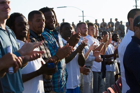 Members of the San Diego Chargers give retired Navy Senior Chief Petty Officer Melissa Haskins a standing ovation after her speech during an evening colors ceremony aboard Marine Corps Air Station Miramar, Calif., June 10. Marines and Sailors of the 3rd Marine Aircraft Wing and MCAS Miramar hosted the event to recognize the services rendered by the San Diego Chargers to honor the military community. Haskins was personally effected by the Chargers when she underwent chemotherapy for leukemia. The team invited her to watch a practice and to eat lunch with them. Haskins claims that moment positively impacted her treatment and was thankful to be able to give recognition and appreciation back to the team.