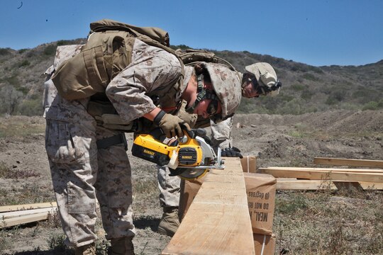 Lance Cpl. Taylor Butler, combat engineer, 2nd Platoon, Bravo Company, 7th Engineer Support Battalion, 1st Marine Logistics Group, saws wooden planks into the proper dimensions necessary for constructing guard towers during a field training exercise aboard Camp Pendleton, Calif., June 12, 2014. The wood was used to construct 20-foot tall guard towers which provided an advantageous position for Marines to post security after building a approximately 40,000 sq. meters forward operating base, a secured and fortified location used to increase operational tempo in forward deployed areas.