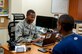 Senior Airman Derrick Davis, 386th Air Expeditionary Wing finance customer service technician and cashier, assists a customer at The Rock with pay issues. Davis deployed from Vandenburg Air Force Base in support of Operation Enduring Freedom and is a native of Lithonia, Georgia. Davis has been deployed here for eight months. (U.S. Air Force photo by Senior Master Sgt. Allison Day)