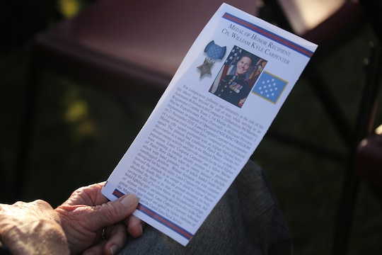 A guest holds a pamphlet showing the citation for the Medal of Honor awarded to Cpl. William “Kyle” Carpenter during an evening colors ceremony aboard Marine Corps Air Station Miramar, Calif., June 23. Carpenter, the most recent Medal of Honor recipient, was awarded for conspicuous gallantry when serving in support of Operation Enduring Freedom in Helmand Province, Afghanistan. Carpenter attended the ceremony as the guest of honor and spoke about the importance of noncommissioned officer in the Marine Corps.