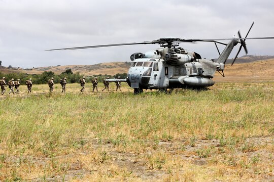 A CH-53E Super Stallion with Marine Heavy Helicopter Squadron (HMH) 465 waits as Marines from 1st Battalion, 1st Marine Regiment, board the aircraft during a training exercise aboard Marine Corps Base Camp Pendleton, Calif., June 27.  Marines held the training to implement communication between air and ground forces. 