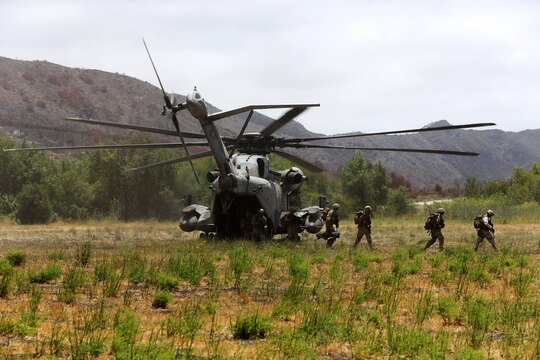 A CH-53E Super Stallion with Marine Heavy Helicopter Squadron (HMH) 465 waits as Marines from 1st Battalion, 1st Marine Regiment, exit the aircraft after being extracted from an objective area during training aboard Marine Corps Base Camp Pendleton, Calif., June 27.  The exercise was conducted so pilots and ground units could apply communication techniques with one another.