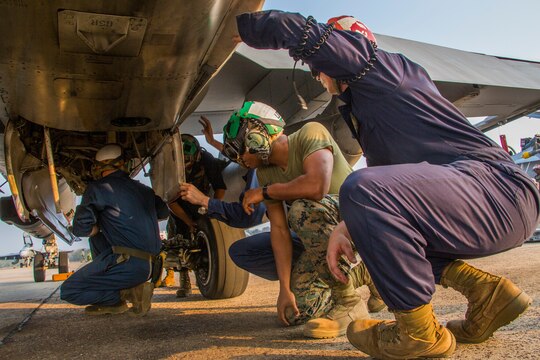 Lance Cpl. Michael Hines, left, and Cpl. Terrence Watts insert engine oil into an FA-18D Hornet aboard Wing One Royal Thai Air Force Base, Nakhon Ratchasima, Kingdom of Thailand, during a preflight check Feb. 20 during Exercise Cobra Gold 2014. CG 14 is a joint, multinational exercise conducted annually in the Kingdom of Thailand aimed at enhancing and increasing multinational interoperability. The Marines and FA-18D Hornet aircraft are with Marine All Weather Fighter Attack Squadron 242, Marine Aircraft Group 12, 1st Marine Aircraft Wing, III Marine Expeditionary Force.
