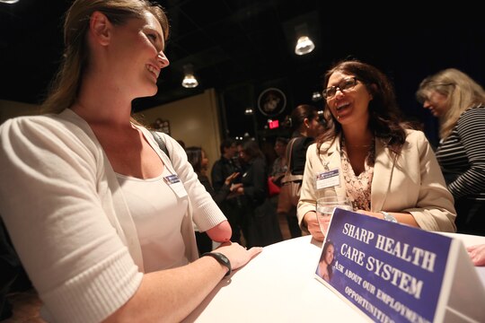 Katherine Harrington, a Navy spouse, speaks with Sharp Health Care System about job opportunities during the Hiring Our Heroes Networking Reception at the Pacific Views Event Center, March 25. The reception was held in order to obtain more knowledge about career planning.

