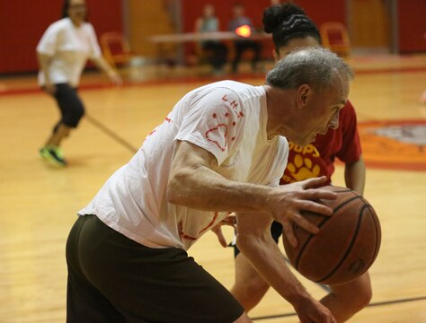 Jeff Carr, a member of the staff team, maneuvers around an opponent during the Lejeune March Madness basketball competition at Lejeune High School, March 21. Carr and the staff team played their way to victory. 