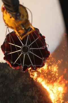 A U.S. Marine Corps CH-53E Super Stallion helicopter, Marine Heavy Helicopter Squadron 462 (HMH-462), Marine Aircraft Group 16, 3rd Marine Aircraft Wing (MAW) collects water in a bambi bucket during aerial firefighting efforts, May 14, 2014. 3rd MAW aircraft partnered with the California Department of Forestry and Fire Protection to conduct aerial firefighting against several wildfires ablaze in San Diego County. (U.S. Marine Corps photo by Staff Sgt. Carl Atherton 3d MAW COMCAM/RELEASED)