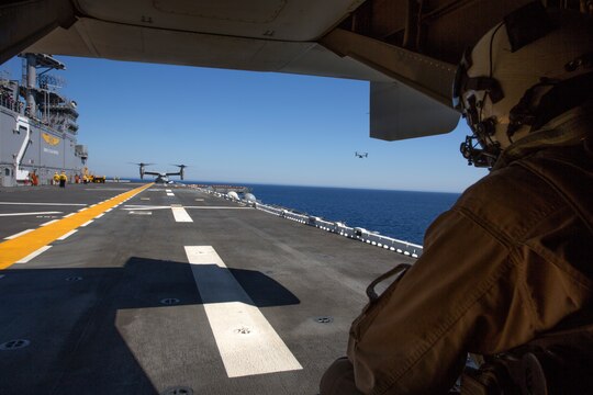 Gunnery Sgt. Marion Phelps, quality assurance chief and crew chief with Marine Medium Tiltrotor Squadron (VMM) 161 “Greyhawks”, watches as aircraft participating in field carrier landing practices land aboard the USS Essex, May 15. The Greyhawks provided two MV-22B Ospreys for the training.  With help from an Osprey from Marine Medium Tiltrotor Squadron 165, they were able to keep their qualifications current while helping the Essex’s crew earn new qualifications.