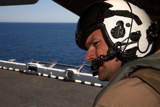 Gunnery Sgt. Marion Phelps, quality assurance chief and crew chief with Marine Medium Tiltrotor Squadron (VMM) 161, checks the aircraft’s clearance from the flight deck superstructure during field carrier landing practices aboard the USS Essex, May 15. Phelps and his fellow crew chiefs ensure pilots can land safely by acting as their eyes and ears during flight. 