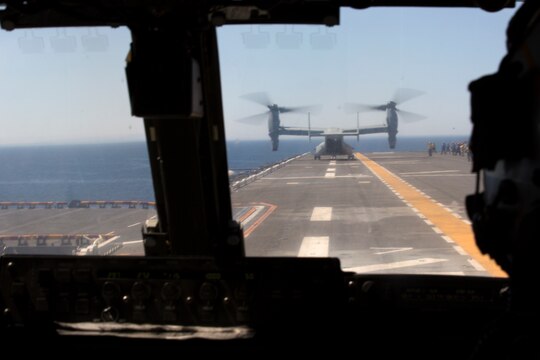 Pilots with Marine Medium Tiltrotor Squadron (VMM) 161 watch as the lead aircraft taxi to the takeoff point during field carrier landing practices aboard the USS Essex, May 15. Marines and Sailors trained together to maintain and earn landing qualifications before an upcoming deployment at sea.