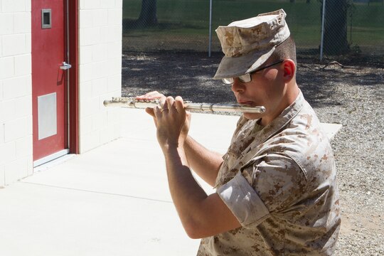 Cpl. Jesse Tingle, a musician with the 3rd Marine Aircraft Wing Band, practices flute outside the band hall, aboard Marine Corps Air Station Miramar, Calif., May 14. Tingle collects historical American flags. He owns several historical flags with various numbers of stars. Some of his prized flags include a modern flag, flown during the dedication of the Miramar National Cemetery, given to him by retired Sgt. Maj. Michael Zacker, a 48-star burial flag, given by a member of his church, and a 45-star flag he purchased last year. He received his favorite flag at an early age, a 48-star flag, given to him by his father. 
