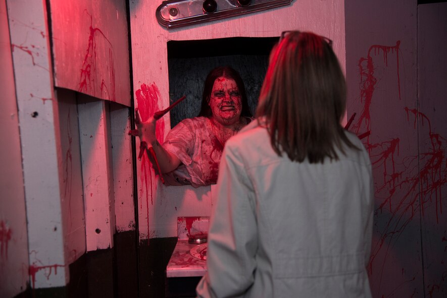 Tiffanie Bullard, wife of U.S. Air Force Staff Sgt. Albert Bullard, 23d Civil Engineer Squadron, lunges at a visitor at the 34th Annual Moody Air Force Base Haunted House Nov. 1, 2014, in Valdosta, Ga. Bullard would scare guests  after they said “Bloody Mary” three times in front of a mirror. (U.S. Air Force photo by Senior Airman Sandra Marrero/Released)
